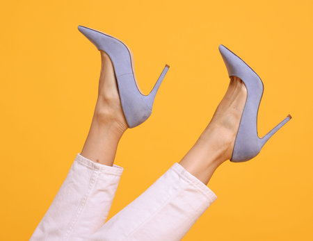 Woman wearing stylish high heeled shoes on orange background, closeupの写真素材