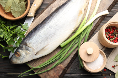 Tasty herring with spices on wooden table, flat layの写真素材