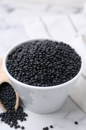 Raw black lentils on white table, closeupの写真素材