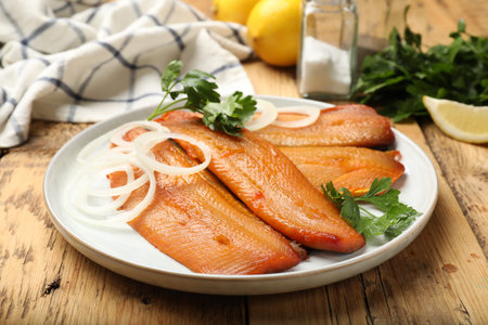 Smoked herrings and spices on wooden table, closeup