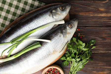 Salted herrings and spices on wooden table, flat lay. Space for textの写真素材