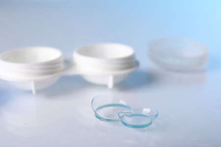 Pair of contact lenses and container on white surface, closeupの写真素材