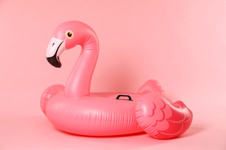 Inflatable flamingo shaped ring on pink backgroundの写真素材