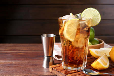 Refreshing Cuba libre cocktail and ingredients on wooden table. Space for textの写真素材