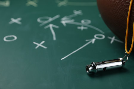 American football ball and whistle on chalkboard with game scheme, closeupの写真素材