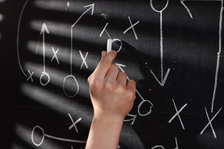 Man drawing American football game scheme on chalkboard, closeupの写真素材