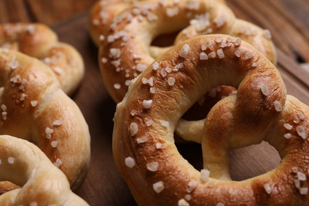 Tasty salted pretzels on wooden table, closeup