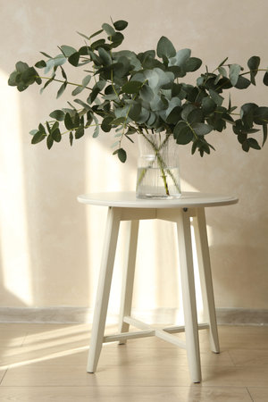 Beautiful eucalyptus branches in vase on table near light grey wall indoorsの写真素材