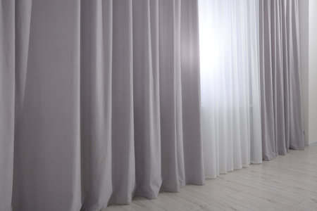 Light gray window curtains and white tulle indoorsの写真素材