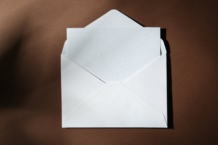 Blank greeting card in paper envelope on brown background, top viewの写真素材