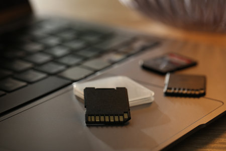 SD memory cards, holder and laptop on table, closeupの写真素材