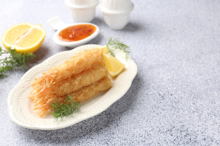 Tasty tempura shrimps, lemon and dill on gray textured table.の写真素材