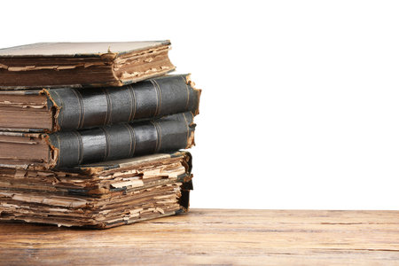 Old books on wooden table against white backgroundの写真素材