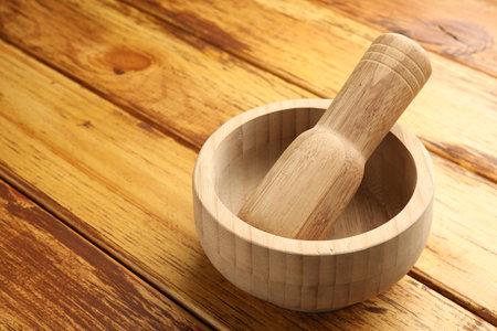 Mortar and pestle on wooden table, closeup. Space for textの写真素材