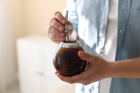 Man with traditional yerba mate tea at home, closeup