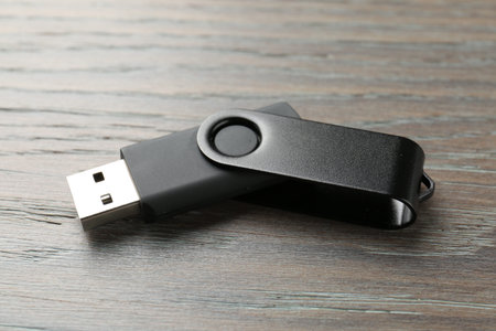 One flash drive on wooden background, closeup