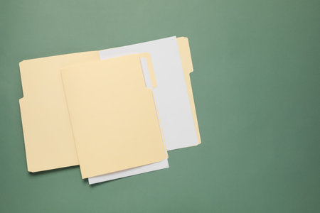 File folders with papers on green background, top view. Space for textの写真素材