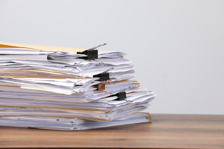 File folders with papers and binder clips on wooden table against gray background, closeup. Space for textの写真素材