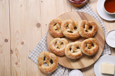 Tasty pretzels, ingredients and tea on wooden table, flat lay. Space for textの写真素材