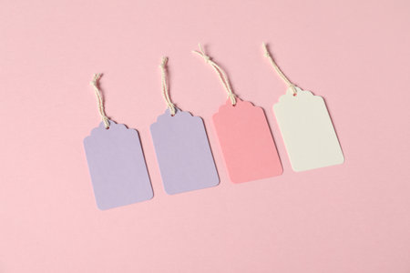 Blank tags with strings on pink background, above viewの写真素材