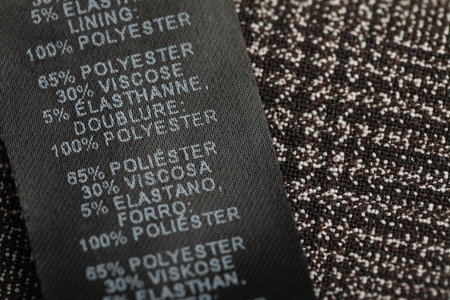 Clothing label in different languages on black garment, closeupの写真素材