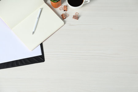 Flat lay composition with office supplies and cup of coffee on light wooden table. Space for textの写真素材