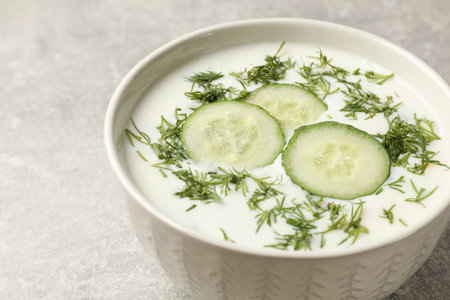 Tasty cucumber soup with dill in bowl on gray textured table, closeupの写真素材
