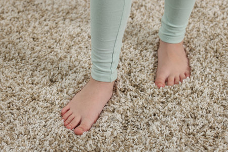 Girl on soft carpet at home, above view