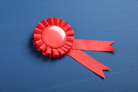 Red award ribbon on blue wooden table, above viewの写真素材