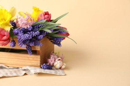Beautiful colorful flowers in crate on beige background. Space for textの写真素材