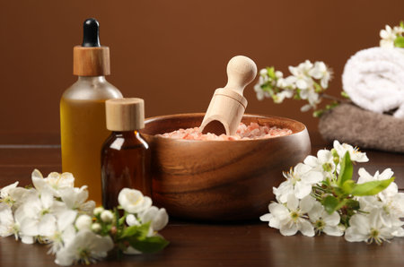 Spa composition with cosmetic products and beautiful flowers on wooden table, closeupの写真素材