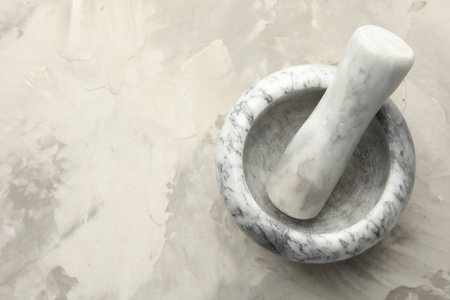 Marble mortar and pestle on gray textured table, top view. Space for textの写真素材