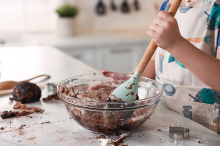 Cooking recipe. Little boy making dough for cookies at table in kitchen, closeup. Space for textの写真素材