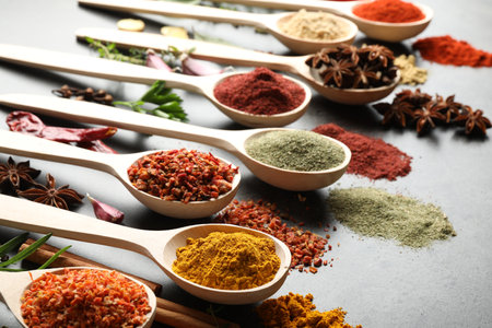 Many different spices in spoons on gray table, closeupの写真素材