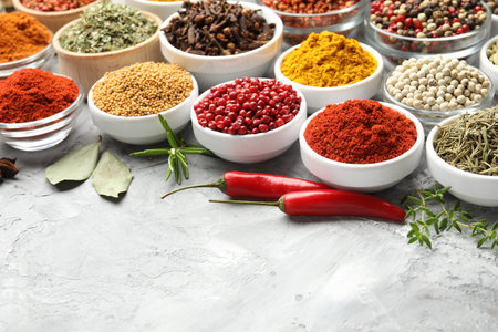 Different aromatic spices on gray table, closeup. Space for text