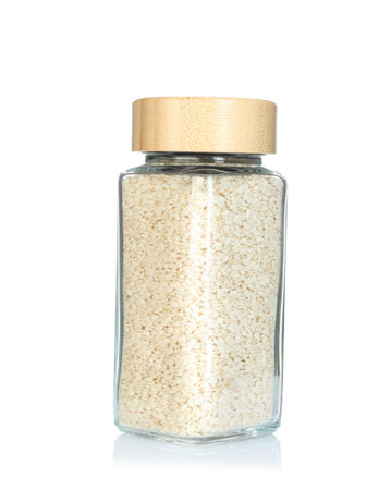 Sesame seeds in spice jar isolated on whiteの写真素材
