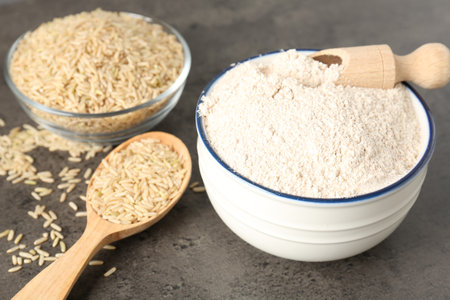 Brown rice and flour on grey table, closeupの写真素材