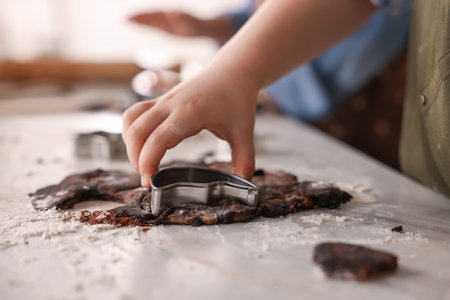 Cooking recipe. Little boy cutting cookie dough with cutters at table indoors, closeupの写真素材