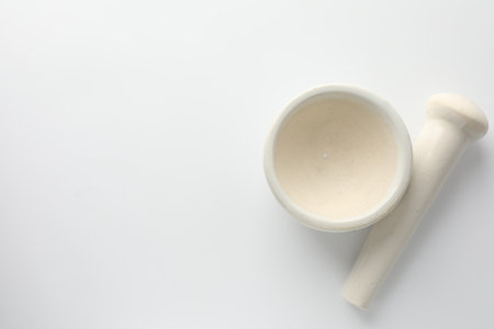 Ceramic mortar with pestle on white background, flat lay. Space for textの写真素材