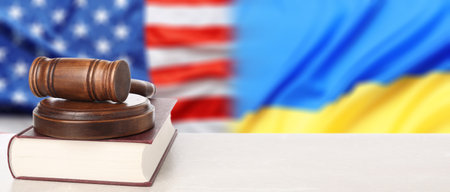 Judge's gavel and book on white table against flags of USA and Ukraine. Banner designの写真素材
