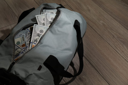 Bag full of dollar banknotes on wooden background, closeup