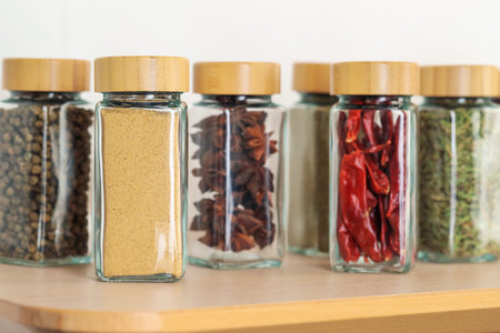 Many different aromatic spices in jars on wooden table indoors, closeupの写真素材