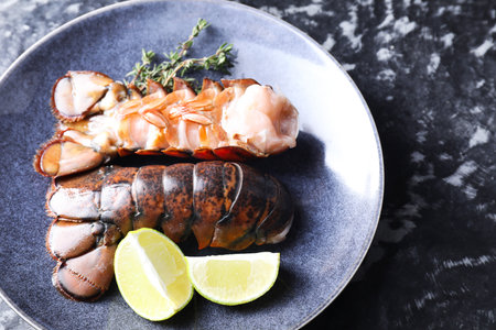 Raw lobster tails, lime and thyme on dark table, above viewの写真素材