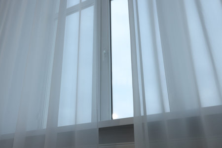 Open window and elegant white curtains indoors. Interior design