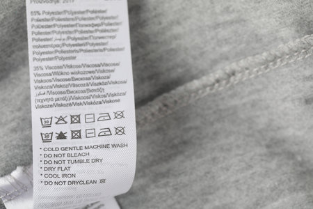 Clothing label with material content on grey garment, above view. Space for textの写真素材