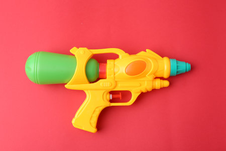 Bright plastic water gun on red background, top viewの写真素材