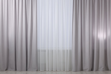 Light grey window curtains and white tulle indoorsの写真素材