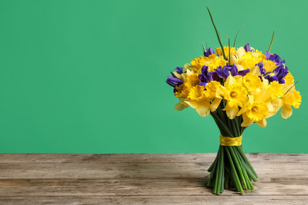 Bunch of beautiful flowers on wooden table against green background. Space for textの写真素材