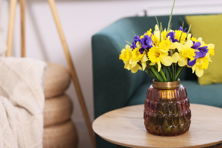 Bouquet of beautiful flowers in vase on coffee table indoors. Space for textの写真素材