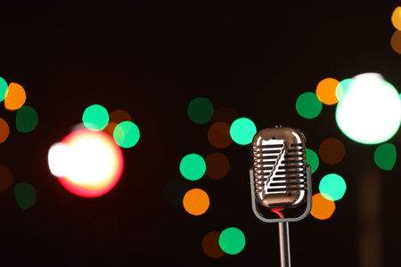Vintage microphone on dark background with blurred lights, space for text.の写真素材